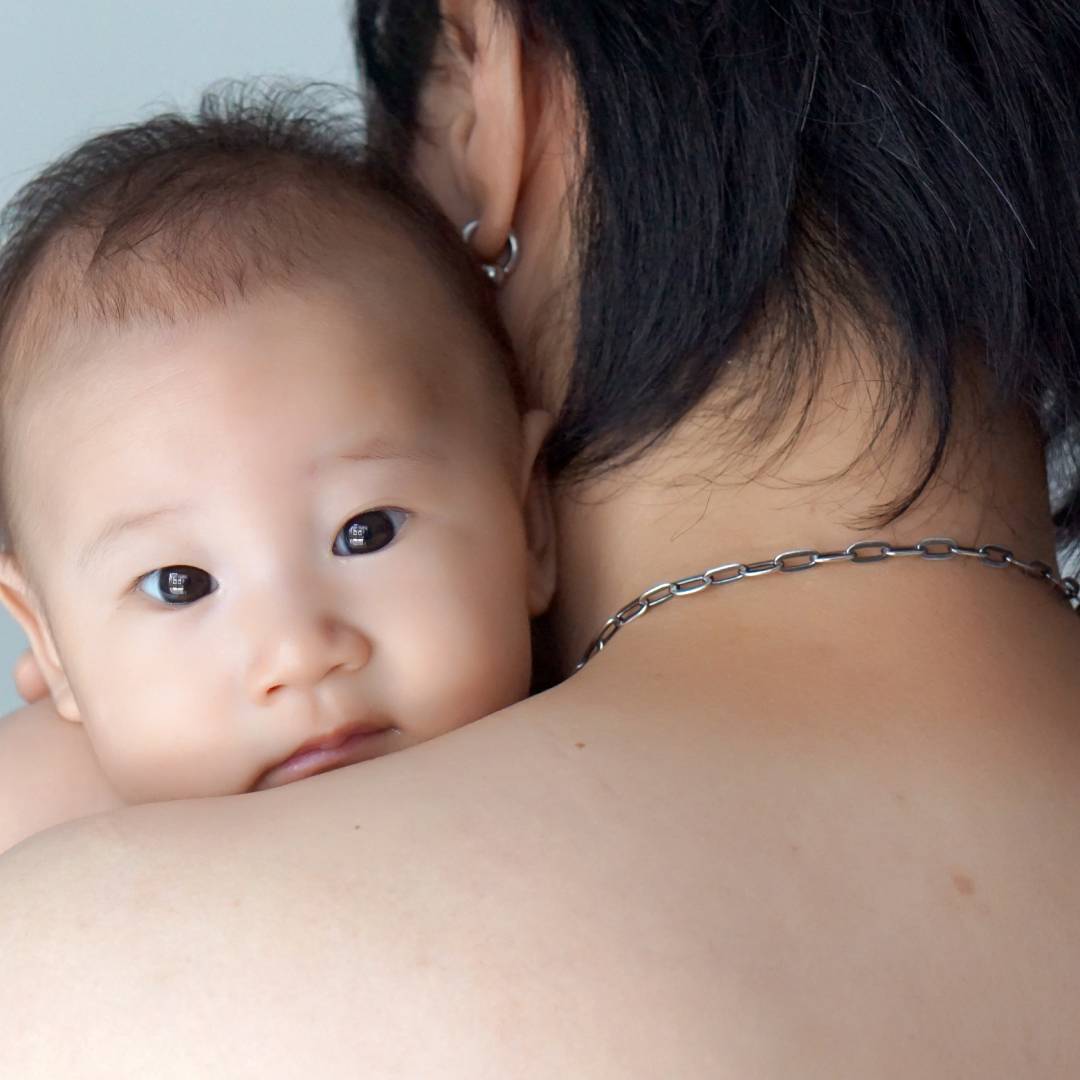 Baby being burped over mother's shoulder