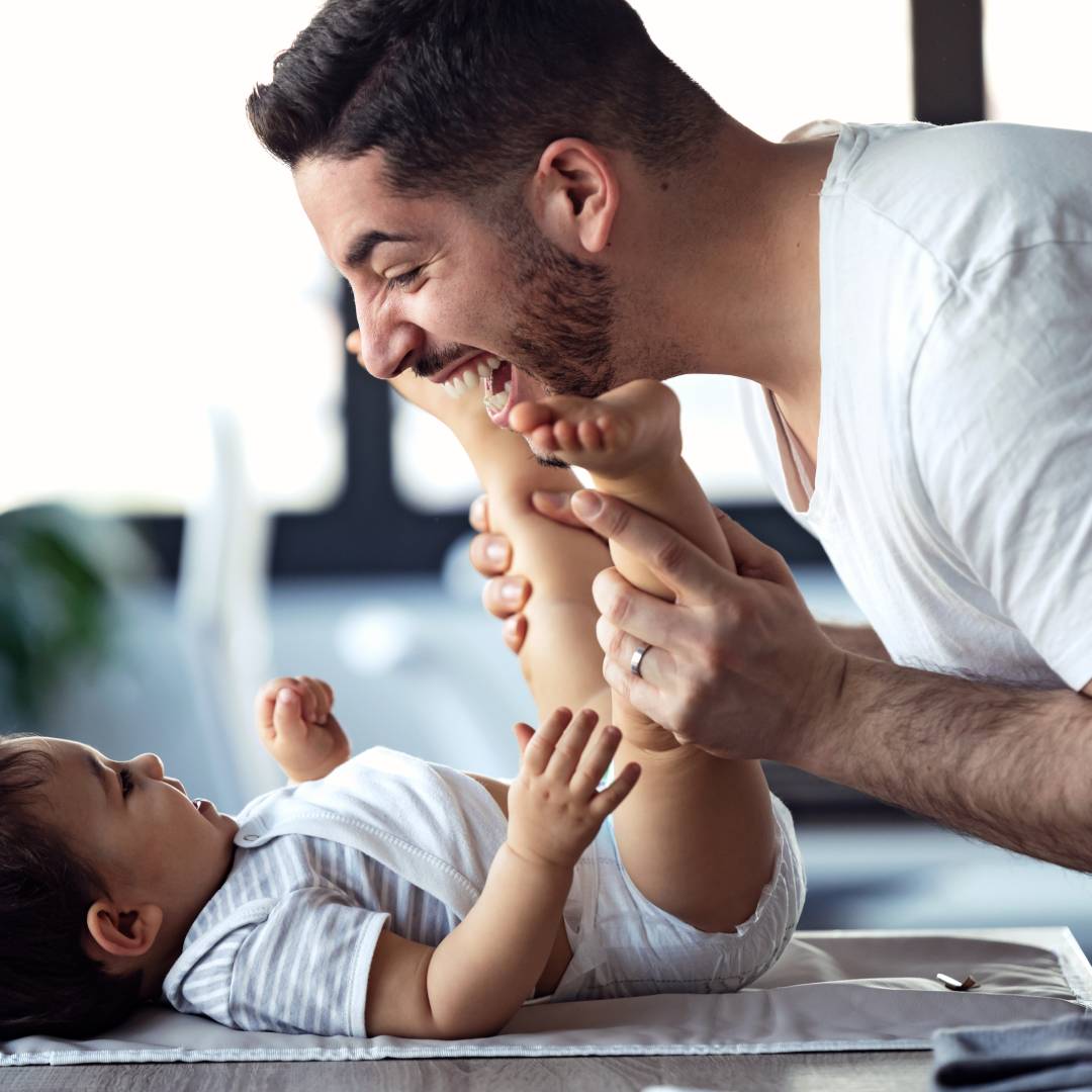 Happy dad and baby smiling after a nappy change